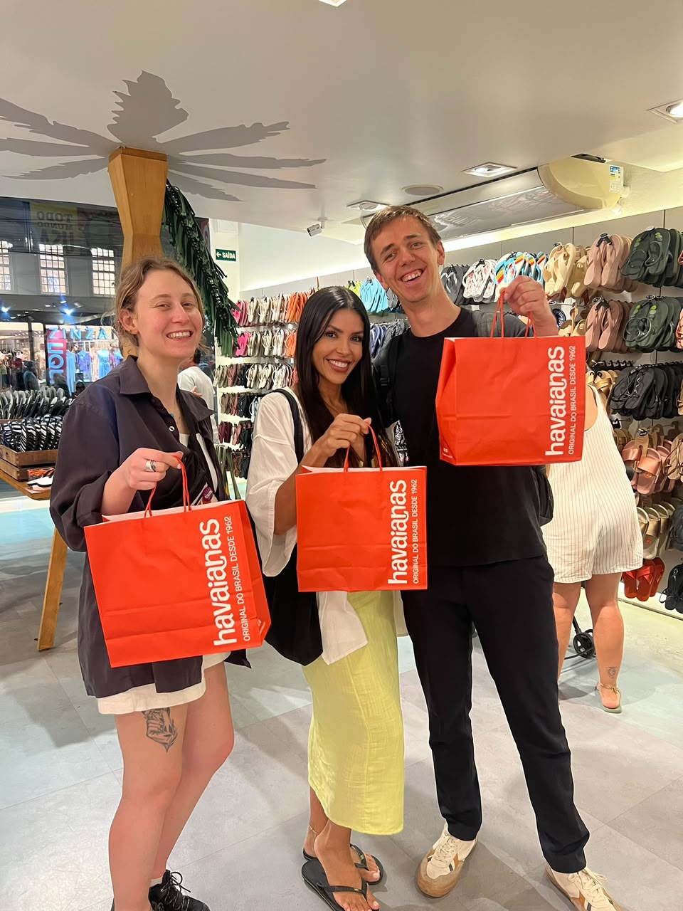Vanessa and guests holding Havaianas shopping bags in a store in Rio