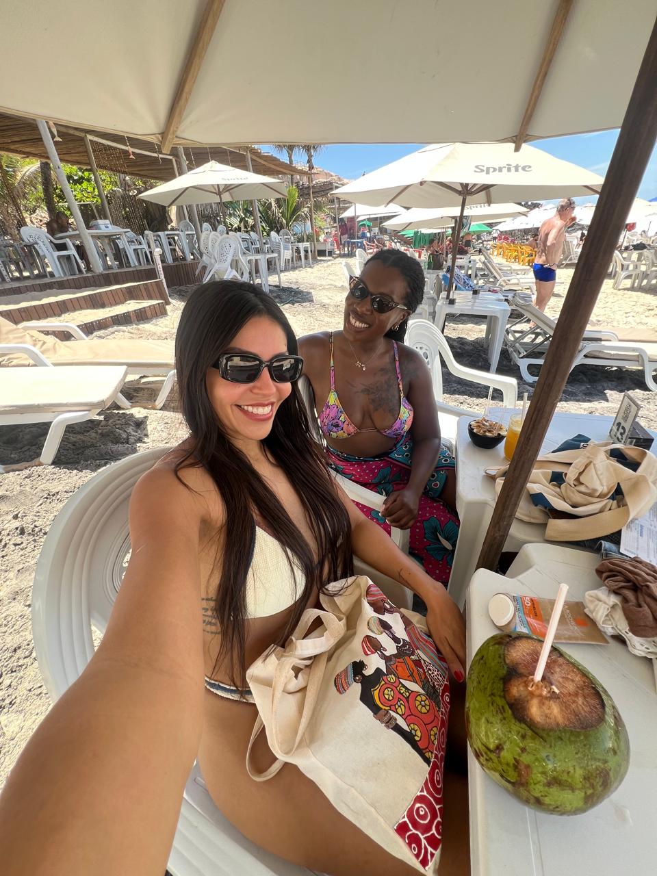 Two guests with a fresh coconut at a beach bar
