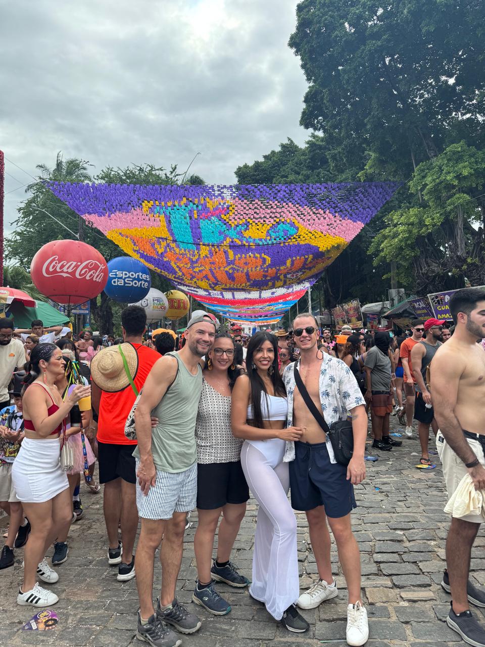 The group together at a street bloco decorated with paper flags
