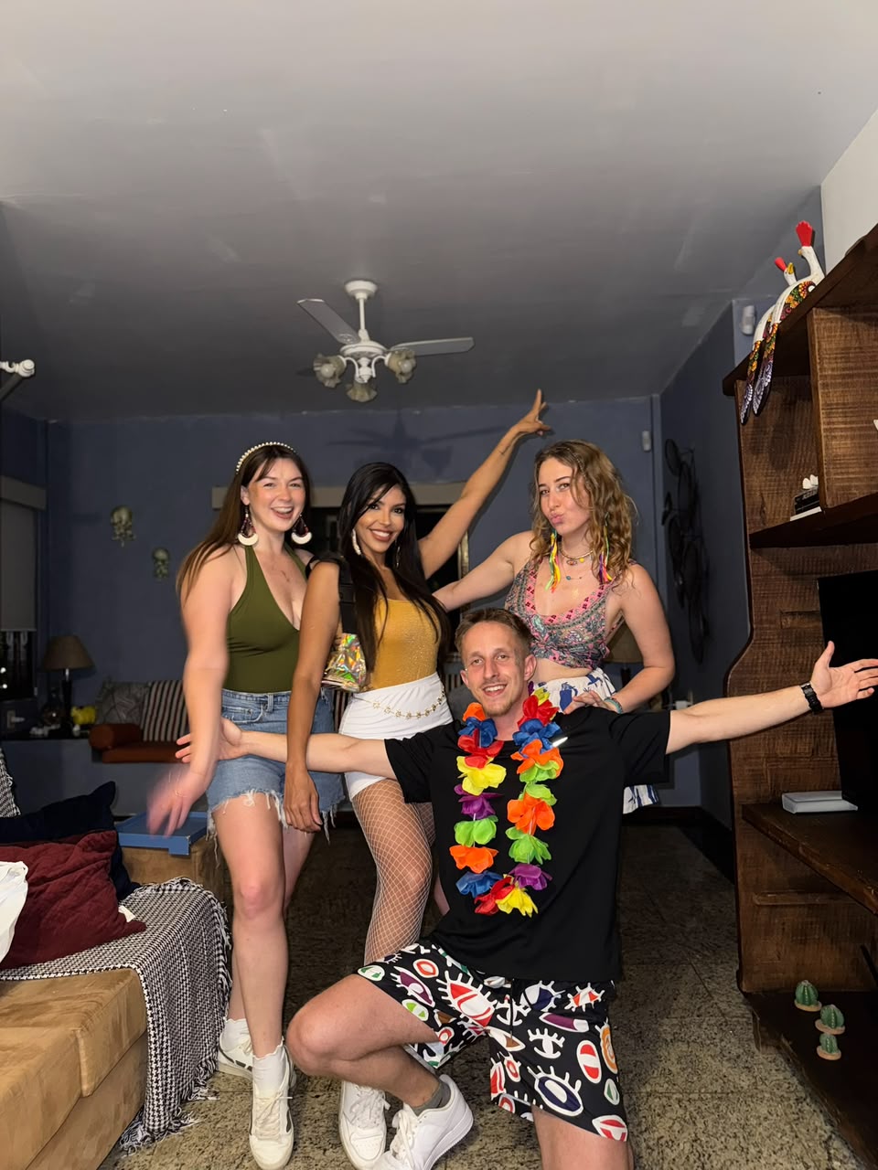 Four friends in Carnival outfits posing together in the living room