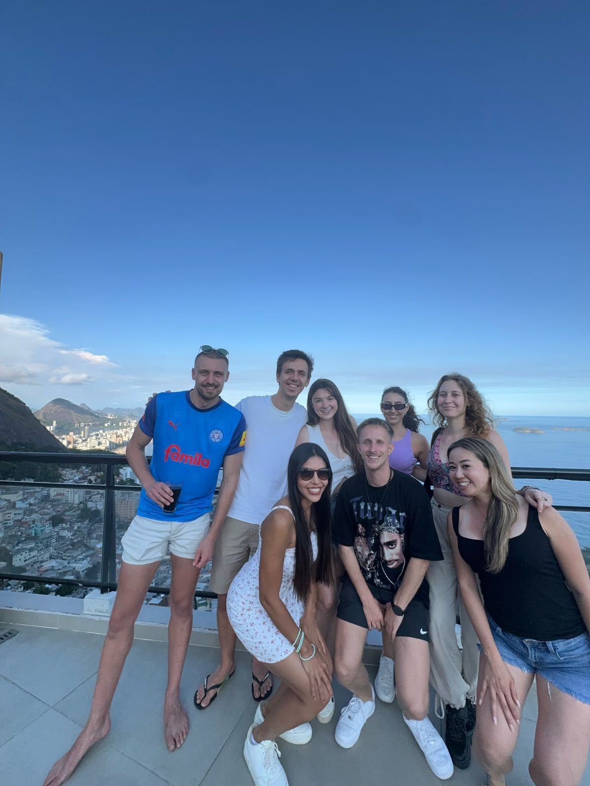 Vanessa's group smiling together at a viewpoint over Rio