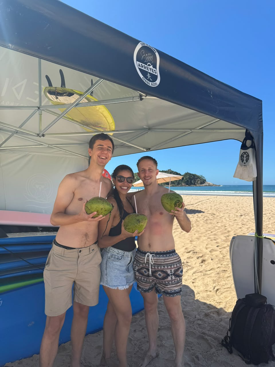 Vanessa and guests with fresh coconuts on a beach in Búzios
